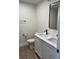 Modern bathroom featuring double sink vanity with white cabinets, black fixtures, and wood-look tile flooring at 4104 Pine Dale Ct, Hernando Beach, FL 34607