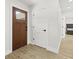 Modern entryway with wood-look tile, interior doors, and view of a bedroom at 4104 Pine Dale Ct, Hernando Beach, FL 34607