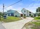 Contemporary stucco home with a well-manicured lawn and a long driveway leading to the front entrance at 4104 Pine Dale Ct, Hernando Beach, FL 34607