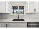 Modern sink features white cabinets, marble countertops and a great view of the water at 4104 Pine Dale Ct, Hernando Beach, FL 34607
