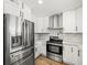 Well-equipped kitchen featuring stainless steel appliances, white cabinets, marble countertops, and wood floors at 4104 Pine Dale Ct, Hernando Beach, FL 34607