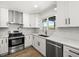 Modern kitchen features white cabinets, stainless steel appliances, marble countertops and a view of the water at 4104 Pine Dale Ct, Hernando Beach, FL 34607