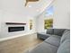Bright living room with a modern fireplace, wood-look flooring, and a comfortable gray sectional sofa at 4104 Pine Dale Ct, Hernando Beach, FL 34607