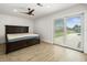 Spacious main bedroom features a large bed, wood-look flooring, and sliding glass doors to the yard at 4104 Pine Dale Ct, Hernando Beach, FL 34607