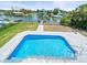 Backyard pool features grey stone border, ladder and waterfront views at 4104 Pine Dale Ct, Hernando Beach, FL 34607