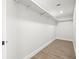 Spacious walk-in closet with white walls, shelf, and light plank flooring at 4104 Pine Dale Ct, Hernando Beach, FL 34607