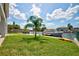 Lush backyard with a palm tree, a boat dock, and a waterfront view at 4469 Bahama Dr, Hernando Beach, FL 34607