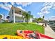 Waterfront backyard featuring a two-story home, palm trees, and a dock with kayaks at 4469 Bahama Dr, Hernando Beach, FL 34607