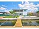 Backyard view of a waterfront home with a wooden dock, a patio, and lush green grass at 4469 Bahama Dr, Hernando Beach, FL 34607