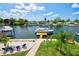 A waterfront backyard featuring a boat dock, lush lawn, and comfortable seating, perfect for relaxing and enjoying the scenery at 4469 Bahama Dr, Hernando Beach, FL 34607