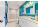 Bright bathroom with blue walls featuring a tiled walk-in shower and marble-top vanity with white cabinets at 4469 Bahama Dr, Hernando Beach, FL 34607