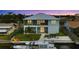 Waterfront home featuring a boat dock, lush lawn, balcony, and charming coastal architecture at sunset at 4469 Bahama Dr, Hernando Beach, FL 34607