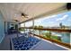 Spacious covered patio featuring dining furniture, ceiling fans and serene waterfront views at 4469 Bahama Dr, Hernando Beach, FL 34607