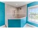Modern tiled shower in a stylish bathroom with turquoise walls and natural light at 4469 Bahama Dr, Hernando Beach, FL 34607