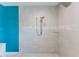 Bright shower with dual shower heads and light gray tiled walls and floor with a stylish blue accent wall at 4469 Bahama Dr, Hernando Beach, FL 34607