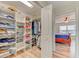 Spacious walk-in closet with custom shelving and wood-look floors leading into bedroom at 4469 Bahama Dr, Hernando Beach, FL 34607
