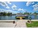 Waterfront view of a boat docked on a canal, with a clear sky and lush greenery at 4469 Bahama Dr, Hernando Beach, FL 34607
