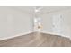 An open bedroom with wood-look flooring, ceiling fan, and white walls provides a bright, blank canvas at 4479 Bluewater Ave, Spring Hill, FL 34606