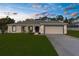 New home's exterior features well manicured lawn and freshly painted facade at 4479 Bluewater Ave, Spring Hill, FL 34606
