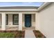 Close-up view of the home's entrance, showcasing a stylish blue front door and attractive landscaping at 4479 Bluewater Ave, Spring Hill, FL 34606