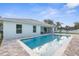 Backyard view showcasing the pool, patio, lush lawn, and modern architecture of the home at 4479 Bluewater Ave, Spring Hill, FL 34606