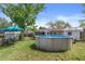 Backyard featuring an above ground pool, a patio set, and mature landscaping at 4537 Cynthia Ln, Spring Hill, FL 34606