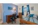 Cozy bedroom with blue accent wall, desk, and comfortable bed, filled with natural light at 4537 Cynthia Ln, Spring Hill, FL 34606