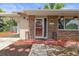 Close-up of the brick-accented front porch with a well-manicured garden bed, showing a tidy and welcoming entrance at 4537 Cynthia Ln, Spring Hill, FL 34606