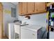Practical laundry room equipped with a washing machine, utility sink, ample cabinet storage, and functional layout for efficient laundry at 4537 Cynthia Ln, Spring Hill, FL 34606