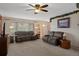 Cozy living room featuring neutral carpet, comfortable sofas, and a ceiling fan, creating a relaxing atmosphere at 4537 Cynthia Ln, Spring Hill, FL 34606