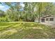 Spacious backyard view with large grassy area, fire pit, and fence at 507 Jewel St, Brooksville, FL 34601