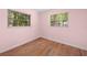 Bedroom featuring wood floors and two large windows offering backyard views at 507 Jewel St, Brooksville, FL 34601