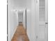 Hallway with hardwood floors, white walls and trim, and closet with louvered door at 507 Jewel St, Brooksville, FL 34601