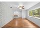Spacious living room featuring hardwood floors, a white brick wall, and natural light from the large window at 507 Jewel St, Brooksville, FL 34601