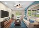 Bright living room features a ceiling fan, a plush sofa and a large window at 507 Jewel St, Brooksville, FL 34601