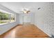 Bright living room with hardwood floors, a large window, and a white brick accent wall at 507 Jewel St, Brooksville, FL 34601