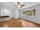 Bright living room with hardwood floors, ceiling fan, large window, and white brick accent wall with planter at 507 Jewel St, Brooksville, FL 34601