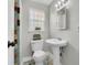 Cozy bathroom features a pedestal sink, mosaic floors, and a window with a plant at 5440 Manatee Point Drive, New Port Richey, FL 34652