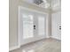 Bright entryway featuring double doors with white shutters, complemented by light gray walls and tile flooring at 5440 Manatee Point Drive, New Port Richey, FL 34652