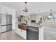 Bright kitchen features an island with a farmhouse sink, marble countertops, stainless steel appliances, and wood-look tile floors at 5440 Manatee Point Drive, New Port Richey, FL 34652