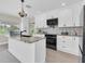 Modern kitchen featuring a large island, white cabinetry, stainless steel appliances, and beautiful countertops at 5440 Manatee Point Drive, New Port Richey, FL 34652