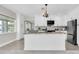 Modern kitchen boasts white cabinets, stainless steel appliances, granite countertops, and views into the living area at 5440 Manatee Point Drive, New Port Richey, FL 34652