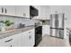 Well-lit kitchen featuring white cabinets, stainless steel appliances, marble countertops, and decorative backsplash at 5440 Manatee Point Drive, New Port Richey, FL 34652