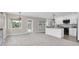 Sunlit living area with open layout showcasing a modern kitchen and an airy, bright ambiance at 5440 Manatee Point Drive, New Port Richey, FL 34652