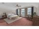 Bright primary bedroom featuring three large windows, neutral paint, ceiling fan and modern furnishings at 5440 Manatee Point Drive, New Port Richey, FL 34652