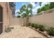 Backyard with a stone landscape, perimeter plants and a tall fence with palm trees in view at 5520 White Marlin Ct, New Port Richey, FL 34652