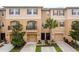 Exterior view of townhomes with a balcony, two-car garages, manicured lawn and palm trees at 5520 White Marlin Ct, New Port Richey, FL 34652