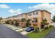 Street view of townhomes featuring two-story exteriors, balconies, and lush green landscaping at 5520 White Marlin Ct, New Port Richey, FL 34652