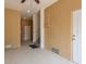 Hallway with a beige painted wall, white trim doors, access to the stairs, and light gray flooring at 5520 White Marlin Ct, New Port Richey, FL 34652