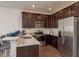 Kitchen with stainless steel appliances, dark wood cabinets, bar-top seating, and stylish pendant lights at 5520 White Marlin Ct, New Port Richey, FL 34652